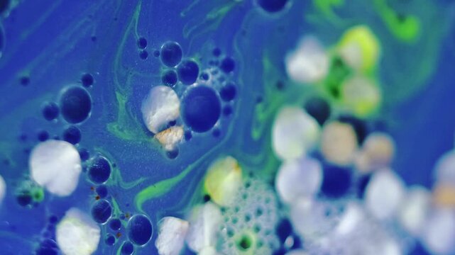 Aroma serum. Gel fluid. Defocused blue white green neon color natural blossom glitter texture mix stripe oil bubble circle abstract background.