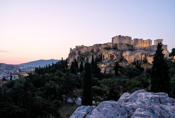 Sunrise view of the Acropolis of Athens, a historic fortress on a rocky hill above Athens, Greece. It features the ruins of several ancient structures, most notably the Parthenon.
