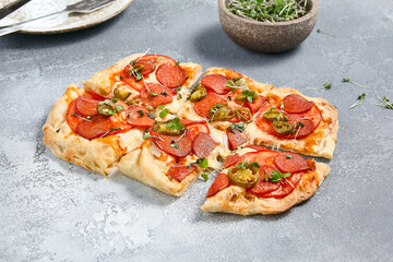 Spicy Roman-Style Pizza with Salami, Pepperoni, and Jalapeno Toppings on Rustic Background