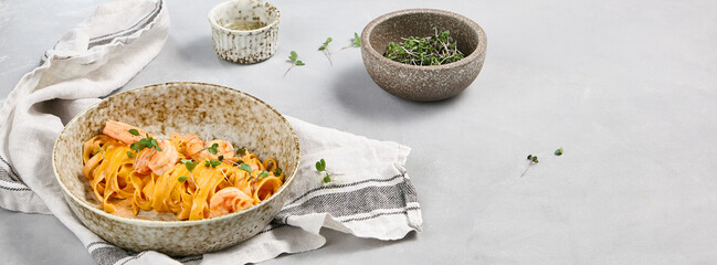 Delicious Creamy Fettuccine Pasta with Shrimps and Fresh Microgreens in Rustic Bowl