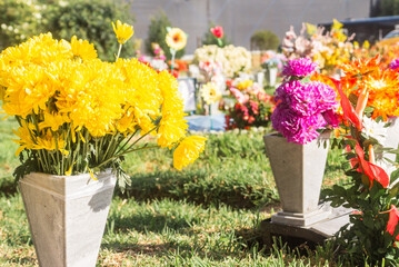 A cemetery with a variety of flowers in vases