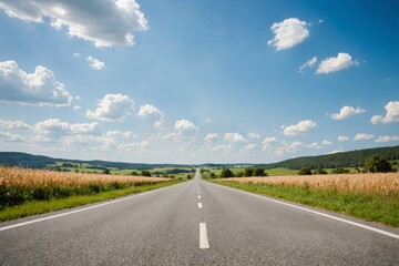 Fototapeta premium vanishing rural road against blue cloudy sky
