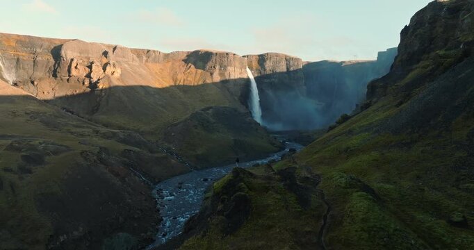 Man Sightseeing Haifoss Waterfall From Rocky Outcrop