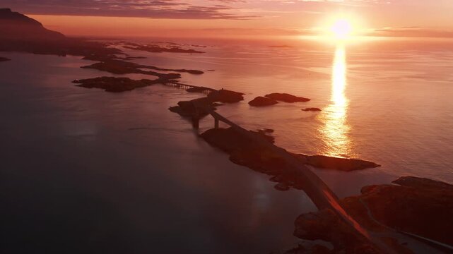 A magnificent sunset over the chain of islands on the Atlantic road connected by the brides. Bright rays of golden sun dance on the surface of the sea.