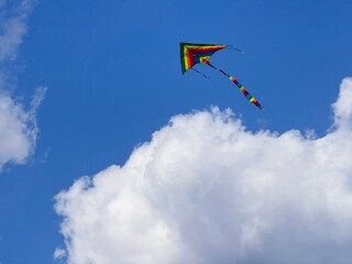 Colorful kite flying in the heaven above clouds