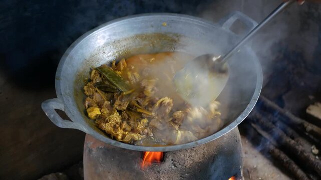 The process of cooking Rendang on a Earthenware furnace or tungku gerabah is Indonesian local stove made from clay, Rendang is a popular traditional indonesian dish