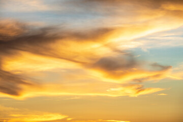 Fototapeta premium Beautiful golden sunrise sky, yellow and blue sky clouds in the summer evening, golden hour, nature as backdrop