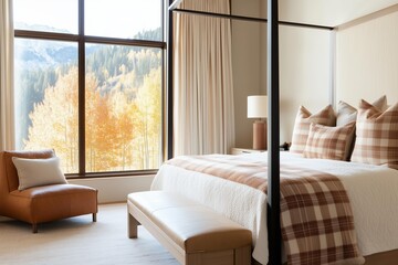 Obraz premium luxurious bedroom featuring a wooden canopy bed with plaid and terracotta colored pillows. The room has large floor-to-ceiling windows offering a scenic autumn mountain view