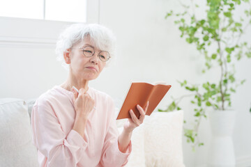 手帳にメモするシニア女性