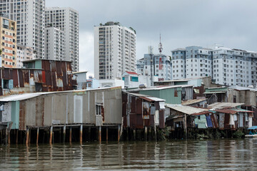 Shanty waterfront houses along Kenh Te canal in contrast with high rise development that has taken place over many years in District four of Ho Chi Minh City, Vietnam