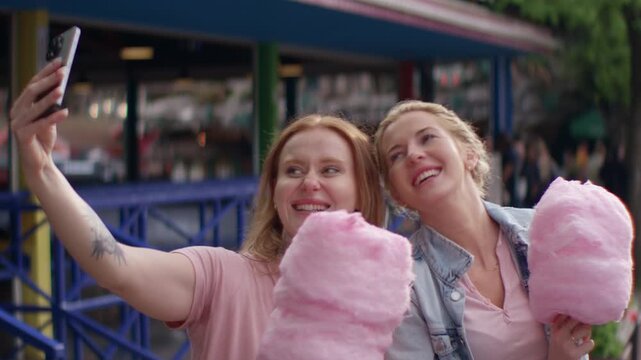 Friends Smiling And Taking Selfie At Fairground