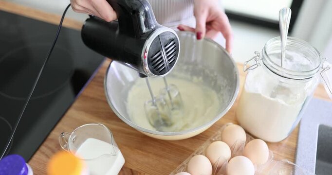 Chef mixes ingredients with electric mixer in bowl