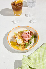 Brioche Bun with Ham, Poached Egg, and Hollandaise Sauce on Sunny Table Setting