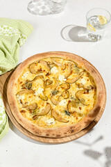 Gourmet Pear and Gorgonzola Pizza on Wooden Board with Green Towel and Water Glass - High Angle, Natural Light