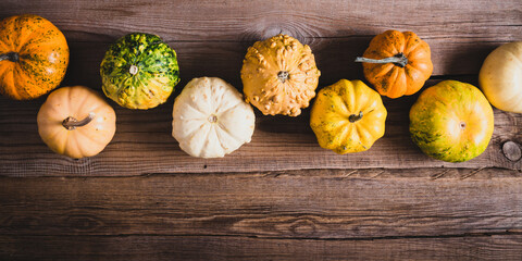 Halloween pumpkin on wooden background. Colorful pumpkins vegetables. Flat lay, top view, copy space