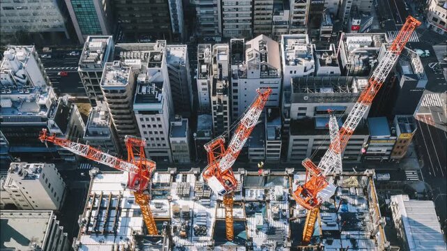 A city skyline with a crane in the middle. The crane is orange and white. The city is busy and bustling