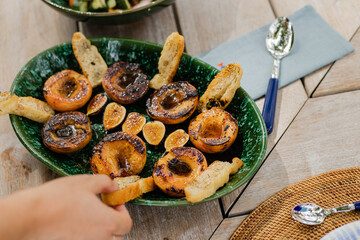 hand reaching for summery grilled bread and peaches on platter