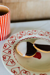 two mini black and white cookies on red and white ceramic plate