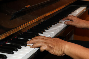 Fototapeta premium A piano is being played by a pianist, the pianist's hands are seen playing the piano keys