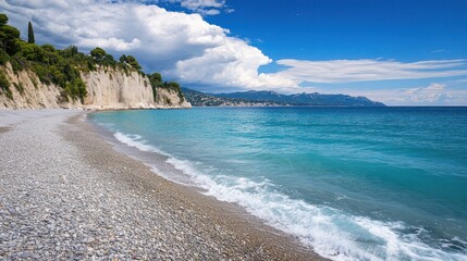 A beach with a large body of water and a few clouds in the sky