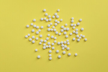 Homeopathic remedy on yellow background, flat lay