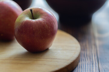 a close-up of a red apple on a wooden board.