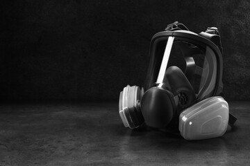 One full face respirator on dark background. Space for text