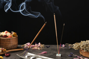 Aromatic incense sticks smoldering on grey table