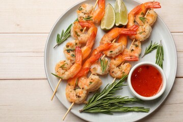 Skewers with delicious grilled shrimps served on wooden table, top view