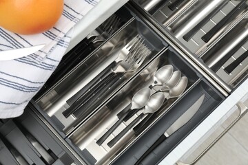Box with cutlery in drawer, top view. Kitchen utensils storage
