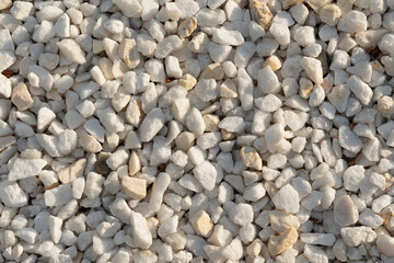 A close-up image of white gravel stones, ideal for backgrounds, textures, and construction-related themes.