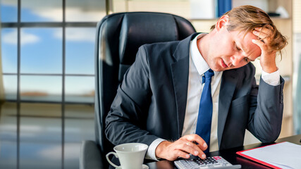 Unhappy businessman using tablet computer while frustrated working on a comfortable place at office	
