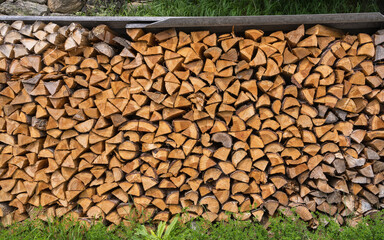 Stacked split logs. Pile of logs ready for winter. Wooden stumps, firewood stacked in a beautiful mountain landscape. High quality phot