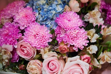 A bouquet of flowers with pink and blue flowers. The flowers are arranged in a way that they complement each other and create a harmonious look