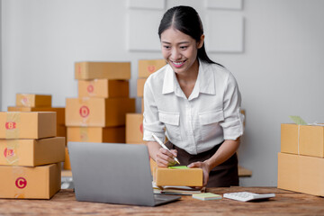 Sme Female ecommerce business owner prepares package box for customer and delivery check balance. asian SME, SME business ideas online.