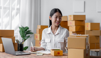 Sme Female ecommerce business owner prepares package box for customer and delivery check balance. asian SME, SME business ideas online.