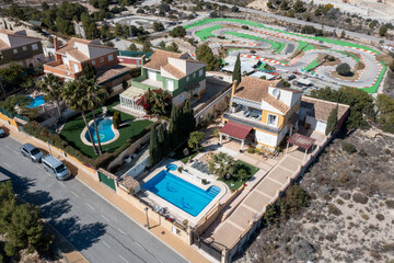 Fototapeta premium Aerial drone photo of a beautiful villa in the city of Benidorm in Spain showing the two story Spanish house with a swimming pool on a hot day in the summer time in the town of Finestrat