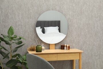 Round mirror on grey wall in room. Interior design