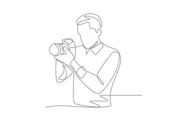 Male photographer preparing to take a photo facing sideways. World photography day concept one-line drawing