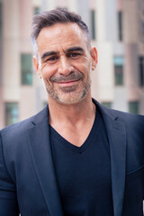 Obraz premium Vertical portrait of serious businessman looking at camera outdoors.