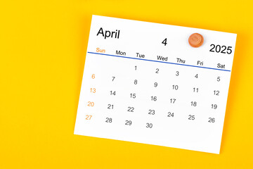 April 2025 and wooden push pin on yellow.
