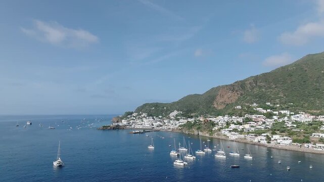 4K Aerial of Panarea, Aeolian Islands. Monring Light Slow push in towards moored yachts in the FG, with Panarea town in the BG