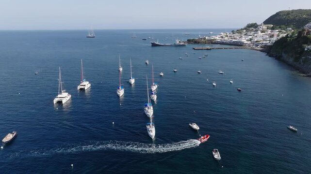 4K Aerial of Panarea, Aeolian Islands. Moored yachts in the FG, with Panarea town in the BG.