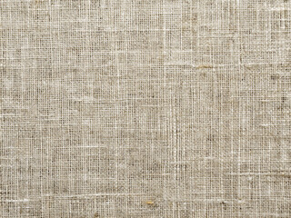 Fototapeta premium Weathered organic linen fabric features a subtle ecru flax pattern, showcasing a rough, textured weave and natural gray tones, perfect for wallpaper or backgrounds.