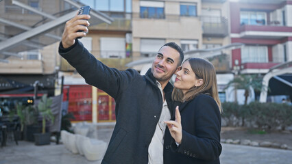 A smiling couple takes a selfie on a vibrant city street, showcasing their love and the urban backdrop.