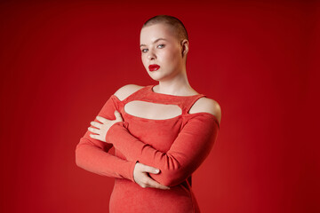 Minimal waist up portrait of sensual vamp girl with short hair posing in studio wearing red dress...