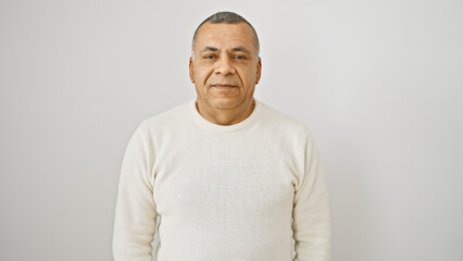 Mature hispanic man in a white sweater posing against an isolated white background, exuding...