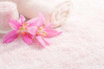 Towel, light pink mineral bath salts and pink Lilies. Spa concept.