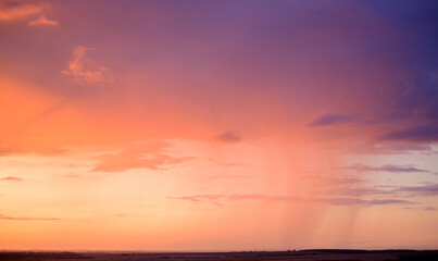 Obraz premium evening violet-orange sky over fields on the horizon