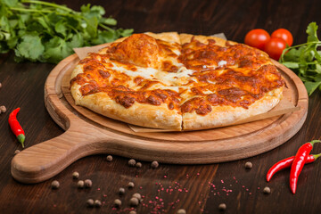 khachapuri with sulguni cheese, herbs and egg on a wooden surface. Georgian pie. Georgian pizza
